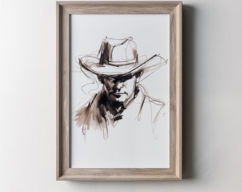 May include: A framed art print featuring a sketch of a person wearing a cowboy hat. The artwork is rendered in shades of brown and black, with visible brushstrokes and lines. The frame is a light wood color, and the text "FLORA IN BLOOM CO." is at the top.