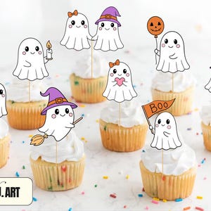 May include: A collection of cupcakes topped with white frosting and decorative ghost-shaped toppers. The ghosts are holding items like a candle, a heart, a broom, and a balloon. The cupcakes are decorated for Halloween.