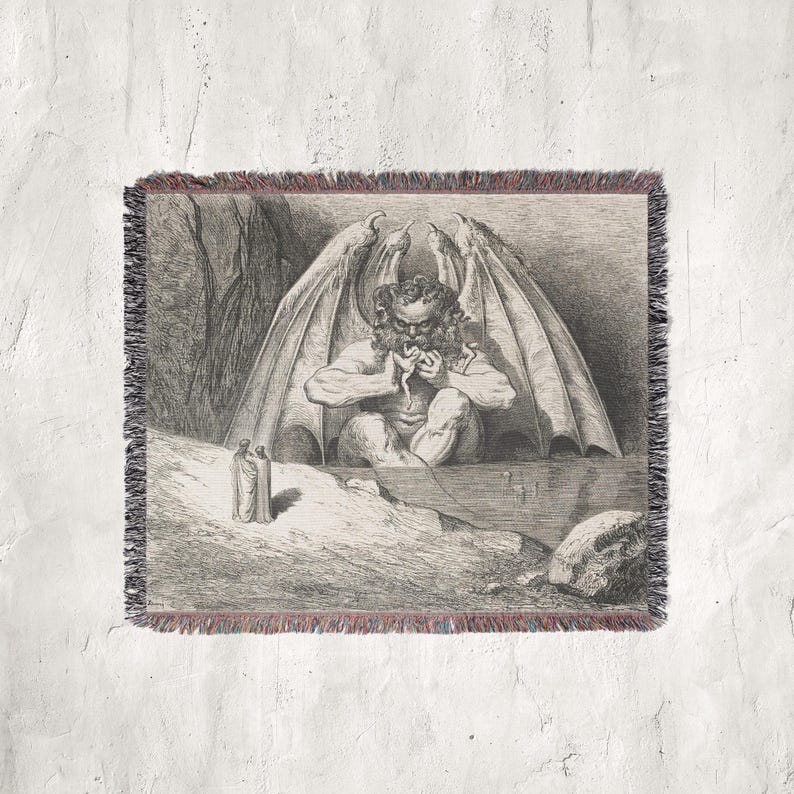 May include: A woven throw blanket featuring a black and white illustration of a winged demon in a cave. The artwork depicts a seated figure with large wings, consuming a snake. The blanket has a fringed edge with red and black accents.