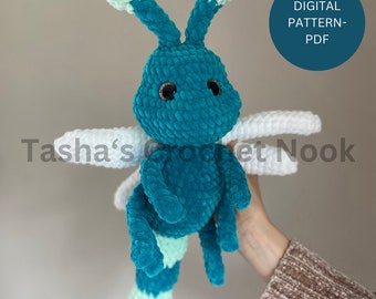 May include: A teal and light green crocheted dragonfly plush toy with white wings and dark eyes. The text DIGITAL PATTERN-PDF is visible in a blue circle, and the text Tasha's Crochet Nook is overlaid across the center of the image.