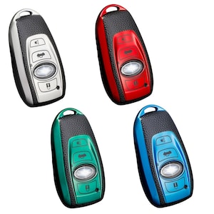 May include: Four car key fobs in silver, red, green, and blue. Each fob has a black leather-textured top and a metallic or coloured plastic base with buttons and a central light. The keys are for a car.