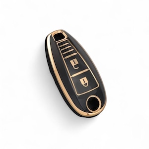 Può includere: Portachiavi per auto nero con finiture dorate. Il portachiavi ha tre pulsanti e un foro circolare. Il portachiavi è su sfondo bianco.