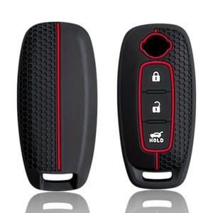 May include: Black key fob cover with a red accent stripe and honeycomb texture. The cover has a red border around the buttons, including lock, unlock, and hold. The Nissan logo is visible.