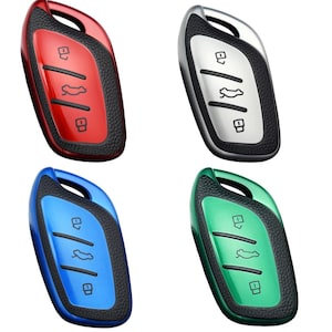 May include: Four car key fobs in red, silver, blue, and green. Each fob has a glossy finish with a textured black border. The keys feature buttons for locking, unlocking, and opening the trunk.