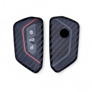 May include: Two black key covers with a carbon fiber pattern. One cover has red accents and three buttons. The other cover has a round hole.