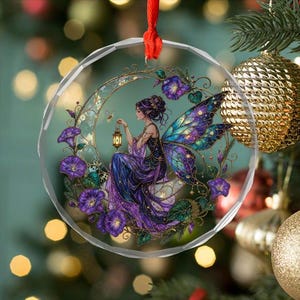 May include: A circular clear acrylic ornament featuring a printed illustration of a fairy with large blue and purple wings sitting on a crescent moon. The fairy holds a small lantern surrounded by purple morning glory flowers and green leaves.