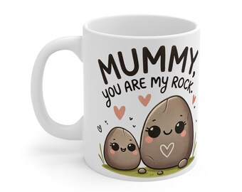 Puede incluir: Taza de cerámica blanca con un diseño de roca de dibujos animados marrón y gris. El texto "MUMMY, you are my rock." está impreso en la taza.