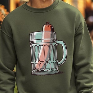 Pode incluir: Uma camisa de frio verde com um gráfico de um copo de cerveja com uma salsicha dentro. A camisa de frio tem um pescoço redondo e mangas compridas.