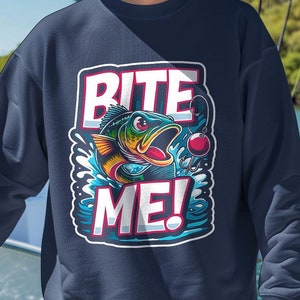 May include: A navy blue sweatshirt with a graphic of a fish jumping out of the water with the text "Bite Me!" printed on it. The fish is colorful and has a red fishing hook in its mouth.