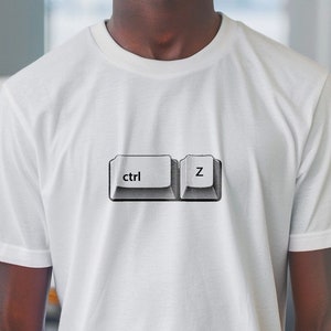 May include: A white t-shirt featuring a graphic of two computer keys, one labelled "ctrl" and the other labelled "z".