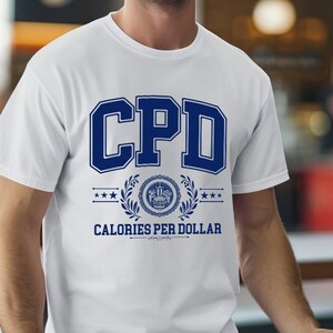 May include: White t-shirt with a blue graphic that says "CPD Calories Per Dollar" with a wreath and stars around the text.