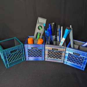 以下が含まれることがあります： 異なるパターンを持つ4つの青と緑のプラスチック製の箱は、デスクオーガナイザーとして使用されています。箱には、ペン、鉛筆、レベル、その他のオフィス用品が入っています。