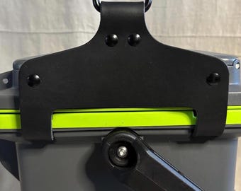 May include: A gray storage container featuring a bright lime green trim and a black handle. A black leather-like strap is secured to the top with four black rivets and includes a black metal ring attached to a swivel clip for hanging.