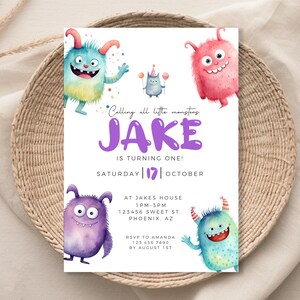 May include: A colorful invitation with a monster theme for a first birthday party. The invitation features a purple, blue, and pink monster with a party hat. The text on the invitation reads "Calling all little monsters Jake is turning one! Saturday 17 October. At Jake's House 1 PM - 3 PM 123456 Sweet St. Phoenix, AZ. RSVP to Amanda 123.456.7890 by August 1st."