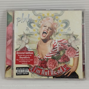May include: A CD case featuring the album "I'm Not Dead" by P!nk. The cover art shows P!nk with pink hair, open-mouthed, surrounded by roses and doves. The album title is in a banner, and a "Special Edition" sticker is visible.