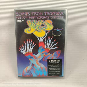 Puede incluir: Caja de DVD de "Songs From Tsongas: Yes 35th Anniversary Concert". La portada presenta el logotipo de la banda en amarillo y un diseño abstracto colorido en rojo, azul y naranja. La caja incluye un set de 2 DVD.