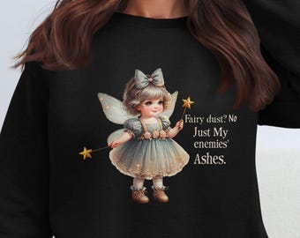May include: Black sweatshirt featuring a graphic of a fairy holding a wand and the text "Fairy dust? No Just My enemies' Ashes."