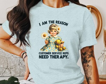 May include: A light blue t-shirt with a graphic of a girl holding a teddy bear. The text on the shirt reads "I am the reason customer service reps need therapy."