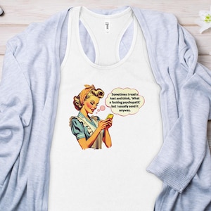 Op de afbeelding: Een wit tanktop met een retro-illustratie van een vrouw in een blauwe jurk en een hoofddoek, die naar haar telefoon kijkt. De tekst op het tanktop luidt: "Sometimes I read a text and think, 'What a fucking psychopath' but I usually send it anyway."