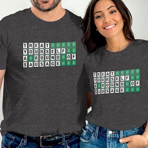 May include: Two heather grey t-shirts with a white graphic that says "Treat Yourself to a Round of Sausage". The graphic is made up of green squares with white letters.