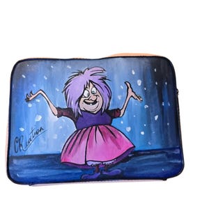 May include: A rectangular laptop sleeve featuring a whimsical illustration of a cartoon character with purple hair and a pink dress. The background is a dark blue with white accents, and the character is smiling with arms outstretched.