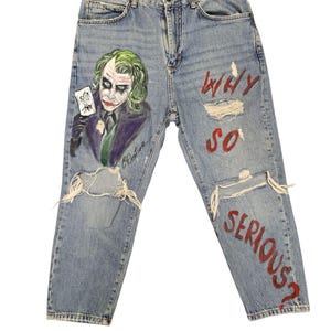 🎨 Descrizione prodotto:  
Pezzo audace e d’impatto per chi ama distinguersi: pantaloni in jeans dipinti a mano con il volto iconico del Joker accompagnato dalla celebre frase "Why so serious?". Ogni dettaglio è realizzato a mano con passione, rendendo questo capo una vera opera d’arte da indossare.