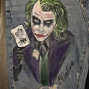 🎨 Descrizione prodotto:  
Pezzo audace e d’impatto per chi ama distinguersi: pantaloni in jeans dipinti a mano con il volto iconico del Joker accompagnato dalla celebre frase "Why so serious?". Ogni dettaglio è realizzato a mano con passione, rendendo questo capo una vera opera d’arte da indossare.