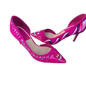 Porta ai tuoi piedi la magia del mondo incantato con queste scarpe con il tacco dipinte a mano, ispirate al mitico Stregatto! Un mix perfetto di stile, ironia e originalità… per chi non ha paura di farsi notare! 😺💫