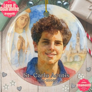 May include: Round Christmas ornament featuring a watercolor portrait of St. Carlo Acutis, with the text "St. Carlo Acutis (1991-2006)". The ornament also includes an image of a religious figure and a gold hanging string.