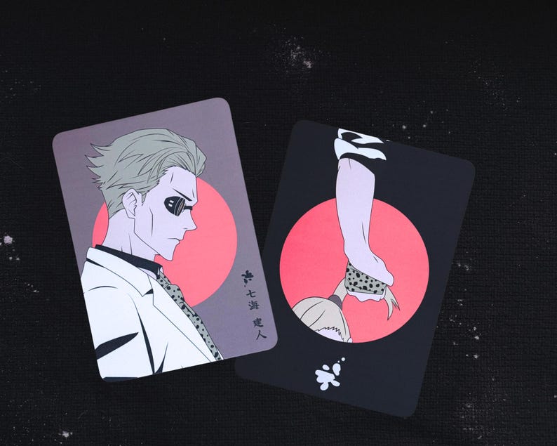 May include: Two rectangular cards with illustrations. One card features a man in a white suit, sunglasses, and gray hair against a pink circle. The other card shows a hand holding a spotted object against a pink circle. Japanese text is visible.