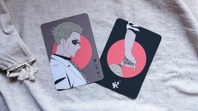 May include: Two rectangular cards with anime-style illustrations. One features a man in a white suit and sunglasses against a red circle, the other a person's arm and neck. Japanese text is visible.