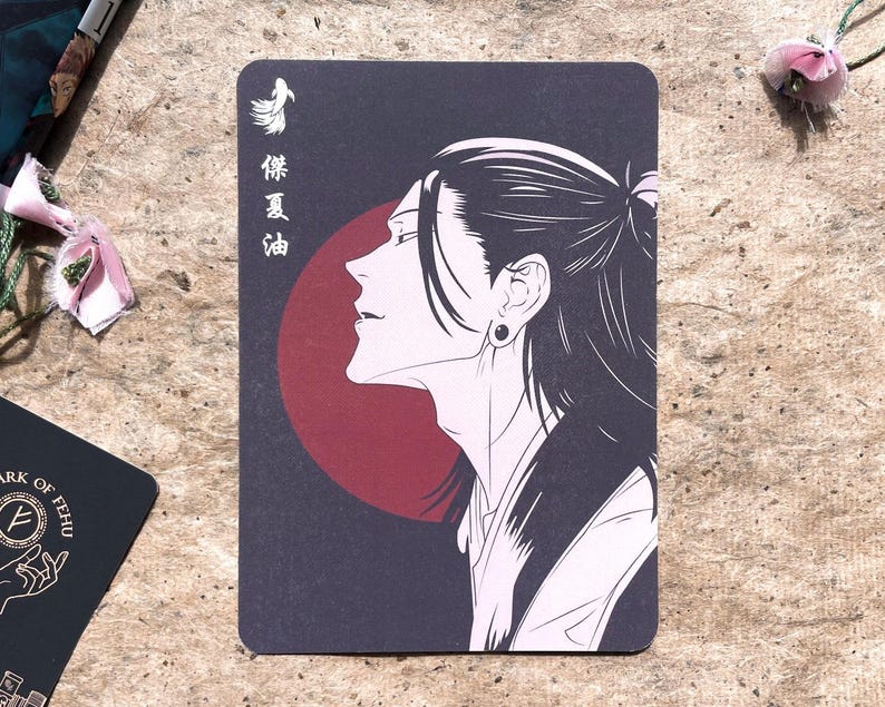 May include: A rectangular card featuring a black and white illustration of a person in profile with long hair. A red circle is behind the person's head. Japanese text is on the left side of the card.