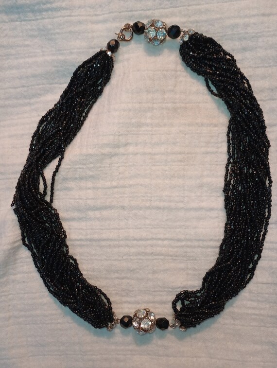 Multi strand black beaded choker with jeweled pend