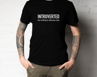 May include: A black t-shirt with white text that reads "Introverted but willing to discuss cats."