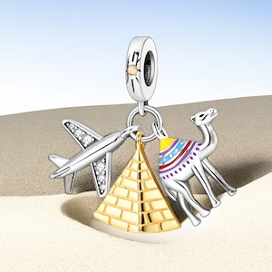 May include: Silver charm with a gold pyramid, a silver airplane, and a camel with a colorful saddle. The charm is designed to represent travel and adventure.