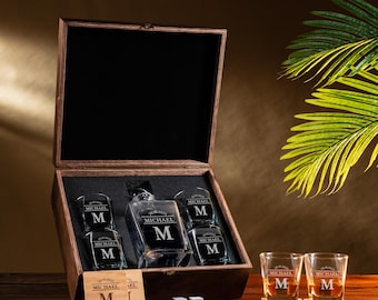 May include: A wooden box set containing a decanter, five glasses, and two coasters. The decanter and glasses are engraved with the letter "M" and the name "MICHAEL". The set also includes two square ice stones and two wooden coasters.