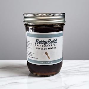 Raspberry honey on a white marble, table.
