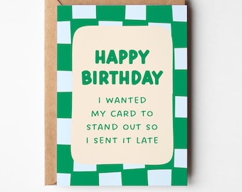 May include: A birthday greeting card with a green and white checkered pattern background. The card has a light beige rectangular shape in the center with the words "HAPPY BIRTHDAY" in green. Below the words is the text: "I WANTED MY CARD TO STAND OUT SO I SENT IT LATE."