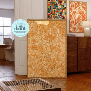 May include: Three digital art prints with abstract patterns in shades of orange, yellow, and blue. The prints are framed in wood and hung on a wall in a modern living room.