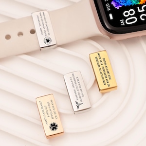 May include: A rose gold smartwatch with a cream strap displays the time and date. Three metal medical alert charms are shown, each with engraved text and a medical symbol. One charm is attached to the watch strap.