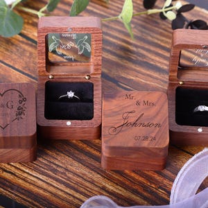 May include: Three wooden ring boxes with different engravings. The first box has a heart with the initials R&G and the words "Forever Yours". The second box has a pair of doves with the words "Forever Yours". The third box has the text "Mr. & Mrs. Johnson 07.28.24".