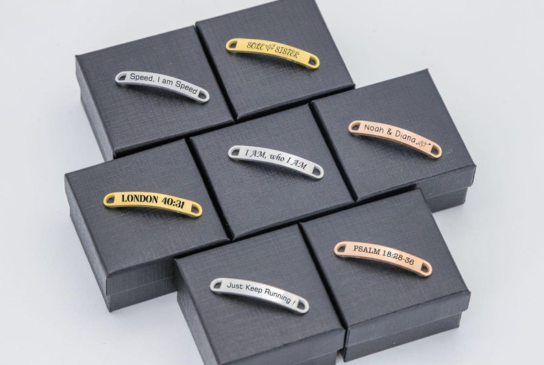 May include: A collection of eight gold, silver, and rose gold shoe charms with various engraved messages, including "Speed, I am Speed", "LONDON 40:31", "SOLE SISTER", "I AM, who I AM", "Just Keep Running", "Noah & Diana", and "PSALM 18:28-36".