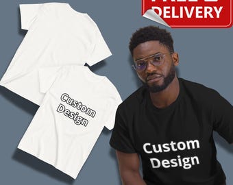May include: Two white t-shirts and a black t-shirt with the words "Custom Design" printed on them. The t-shirts are short-sleeved and appear to be made of cotton. A red sign with the words "FREE DELIVERY" is in the upper right corner.