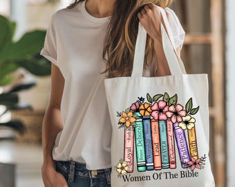 May include: A white tote bag with a colorful floral design and the text "Women of the Bible". The floral design features a stack of books with names of women from the Bible, such as Ruth, Deborah, Esther, and Hannah.