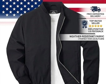 May include: A solid black bomber jacket featuring a ribbed collar, cuffs, and hem, with a full-length silver-toned front zipper closure. The jacket is layered over a plain white crew neck shirt, showcasing a clean, structured design with long sleeves.
