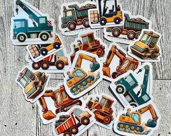 Könnte beinhalten: Ein Set mit 12 bunten Aufklebern von Baufahrzeugen. Die Aufkleber zeigen verschiedene Fahrzeuge, darunter einen Kipplaster, einen Kran, einen Bulldozer und einen Bagger. Die Aufkleber sind perfekt, um jedem Projekt eine lustige Note zu verleihen.