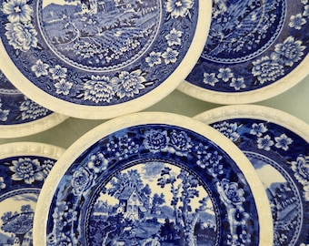 Puede incluir: Juego de seis platos de cerámica azul y blanco con borde floral y un diseño central de una cabaña en un paisaje.