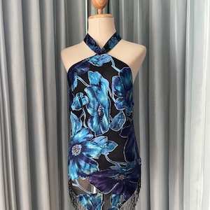 May include: A black halter top with a blue and purple floral print and black fringe trim.