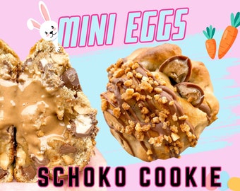 Puede incluir: Dos galletas de chocolate con mini huevos de chocolate en su interior. Una galleta está abierta para mostrar los mini huevos de chocolate. Las galletas están cubiertas de chocolate y nueces picadas. El fondo es rosa y azul con un conejo y zanahorias.