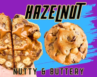 May include: Close-up of two hazelnut cookies, one broken in half to show the inside. The cookie is filled with chocolate chips and hazelnuts. The broken cookie is topped with a dollop of hazelnut spread. The text "HAZELNUT" is in large black letters above the cookies. The text "NUTTY & BUTTERY" is below the cookies.